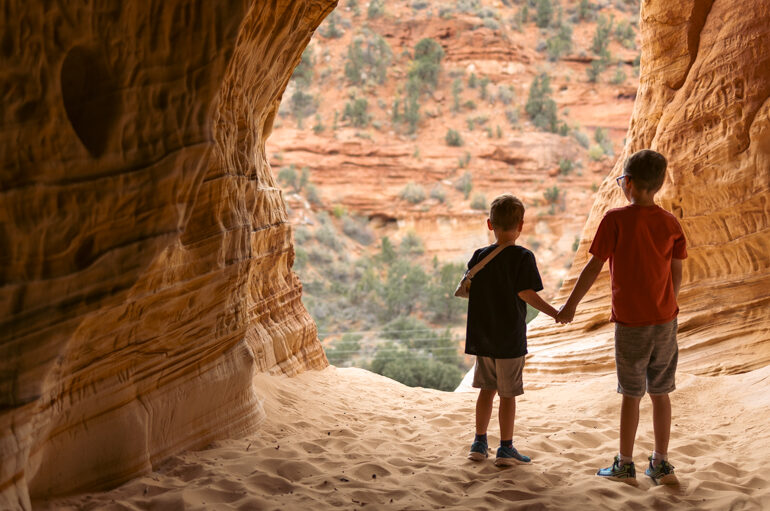 Two children in a sandstone slot canyon near Kanab